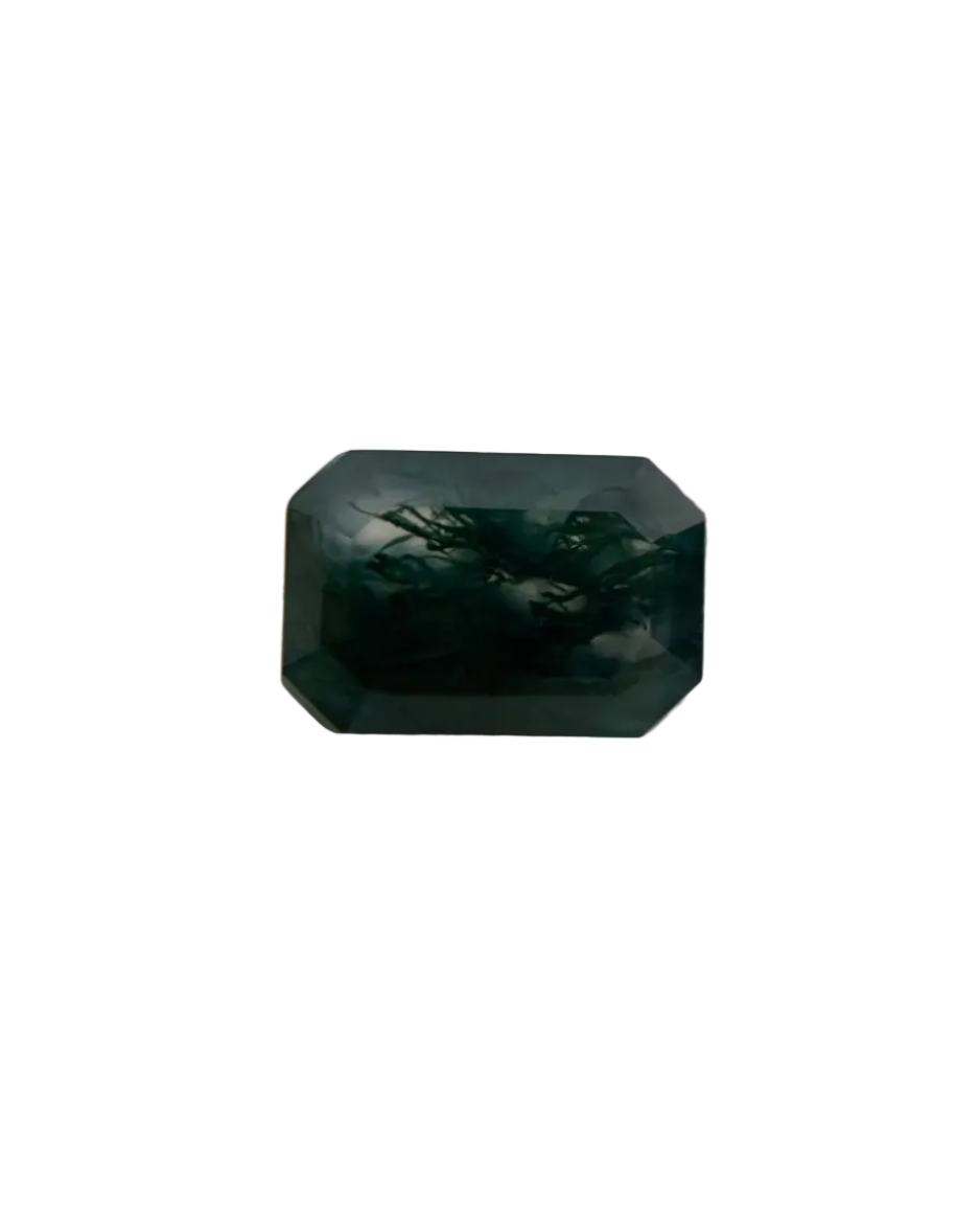 Faceted green gemstone on a textured gray background