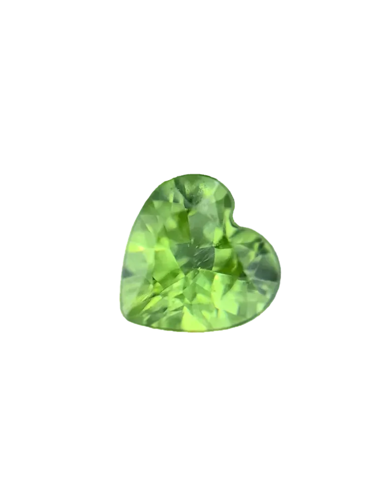 Heart-shaped green gemstone on a dark reflective surface