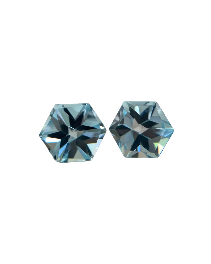 Two faceted blue gemstones on a textured surface