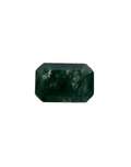 Faceted green gemstone on a textured surface
