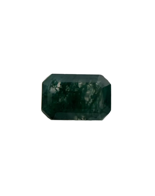 Faceted green gemstone on a textured surface