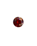 Round red gemstone on a wooden background