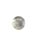 Faceted gemstone on a textured surface with a blurred background